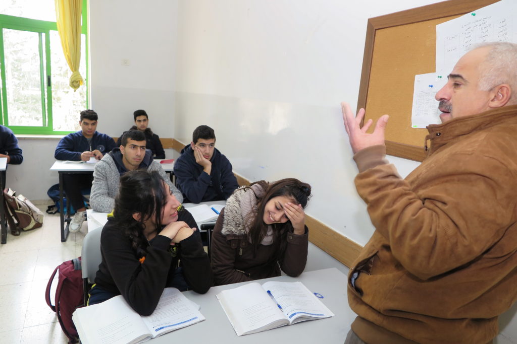 Bild på ett klassrum med en lärare och några elever.