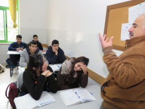 Bild på ett klassrum med en lärare och några elever.