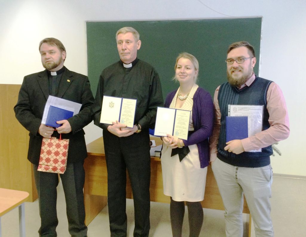 Bild från en utexaminering vid Teologiska Institutet i Ryssland. Fyra nyss utexaminerade personer står på rad.