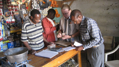 Missionär Mikko Pyhtilä inhandlar byggnadsmaterial av köpman Peter Sosomalle (till vänster). Ledande evangelist Nathanel Mkumbo (till höger) och Mwabusalu församlings sekreterare Josef Mitanda (i bakgrunden) granskar inköpen. Foto Sebastian Alloys
