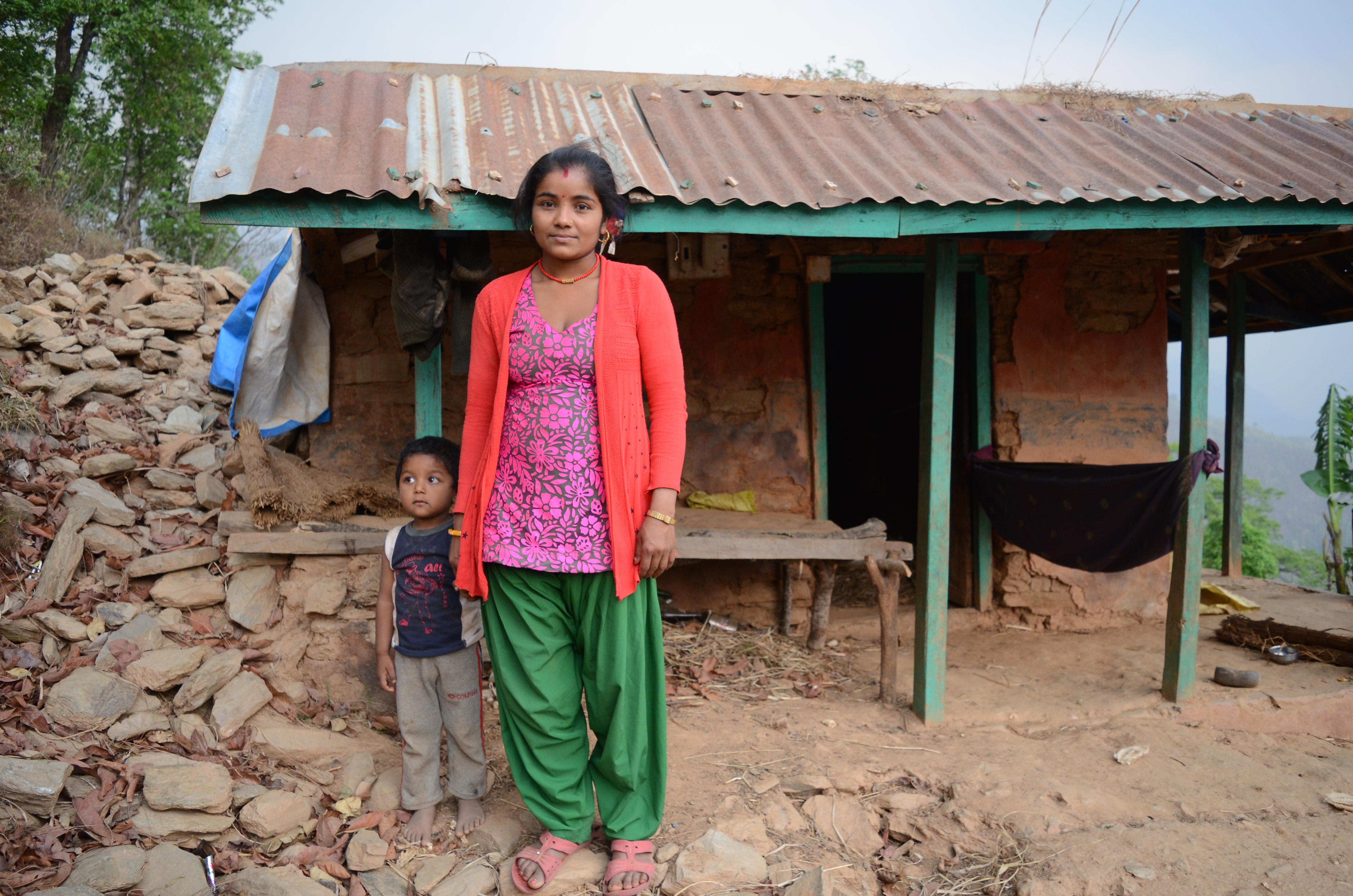 Chandra Kumari Pariyar och treåriga sonen Shajan står framför sitt hus som förstördes i jordbävningen. Familjen hade använt alla sina besparingar till att bygga ett hem